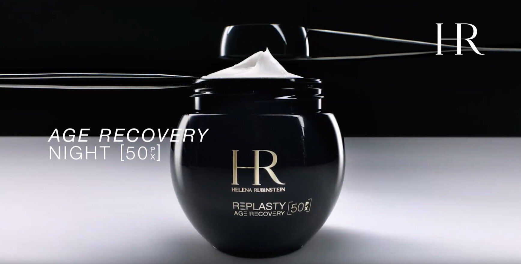 Video del nuovo vasetto ricaricabile Helena Rubinstein Re-Plasty Age Recovery [50PX], aperto con la crema visibile all'interno, presentato su uno sfondo scuro.​