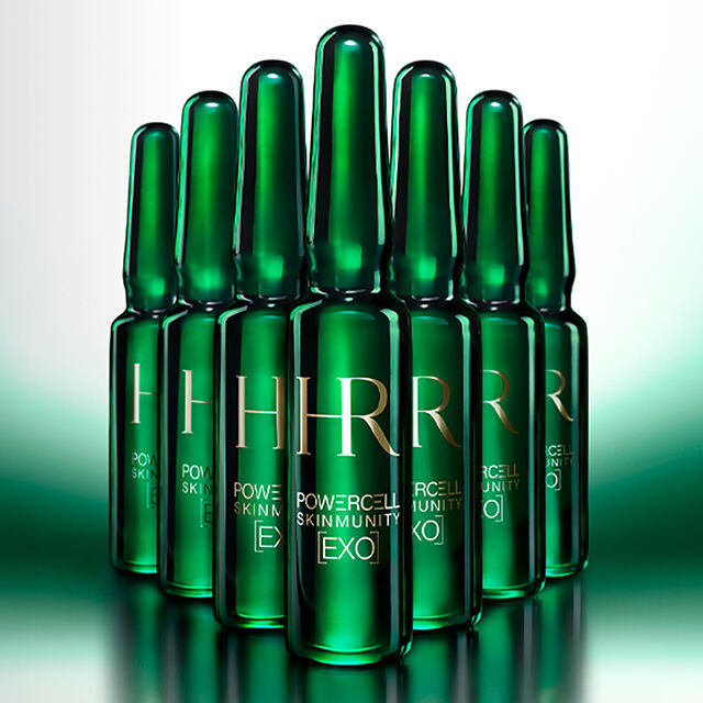 7 fiale verdi in primo piano su uno sfondo verde illuminato.