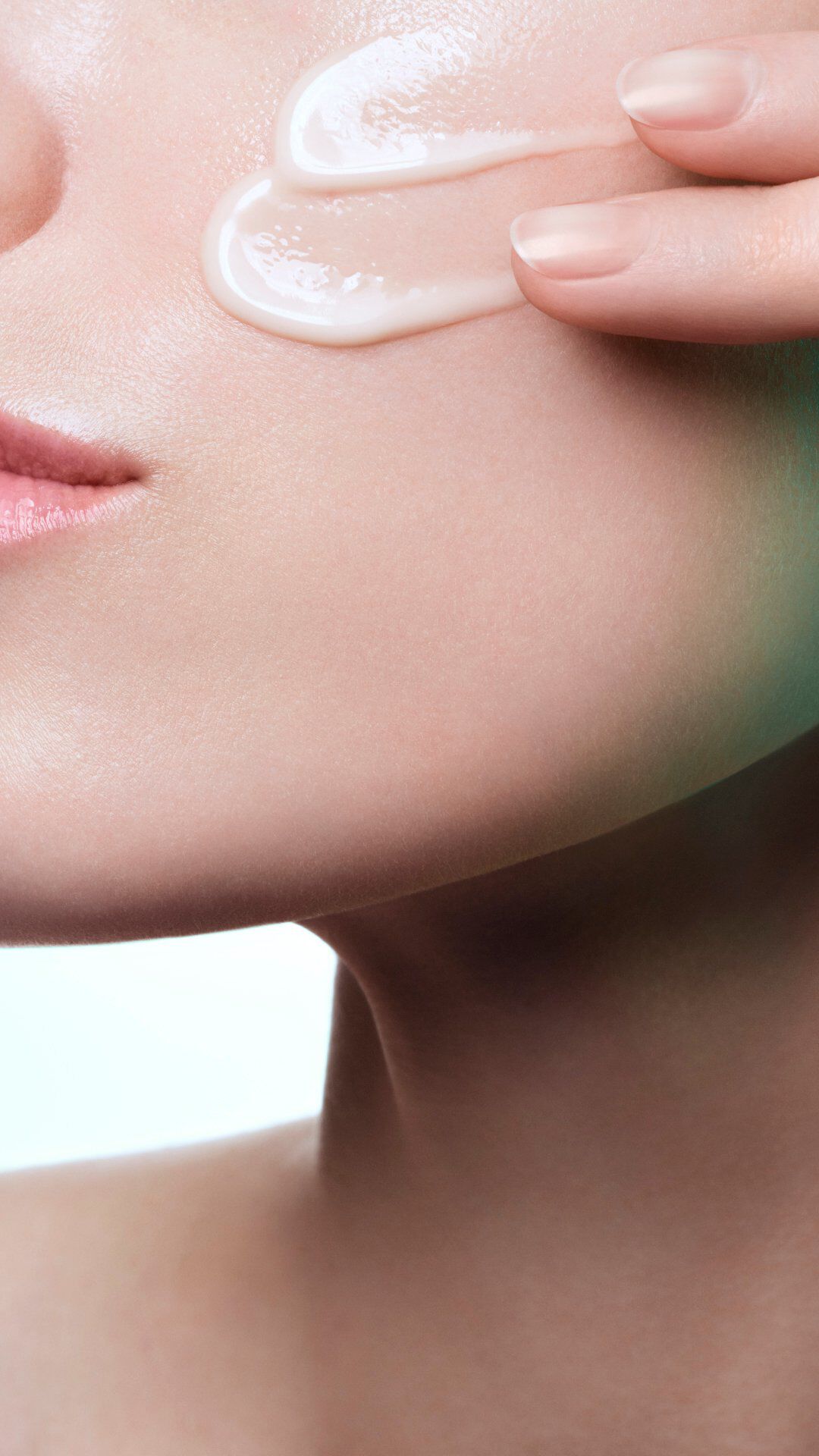 Viso di una donna con una striscia di crema bianca sulla guancia.