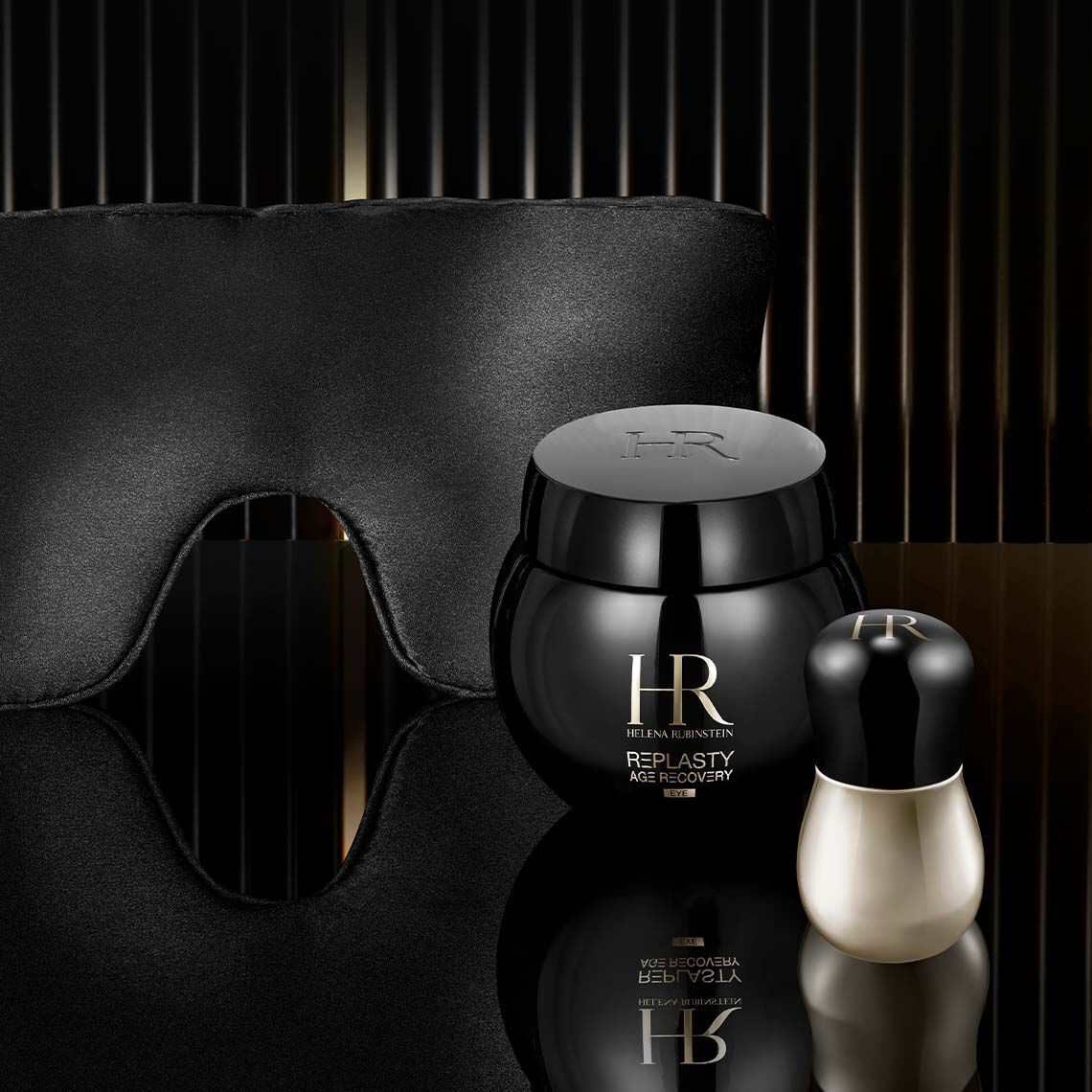 Vasetto di Helena Rubinstein Replasty Age Recovery Eye Night Care presentato con una maschera per dormire in seta di lusso e un applicatore di precisione per illustrare un rituale di riparazione notturna degli occhi premium.