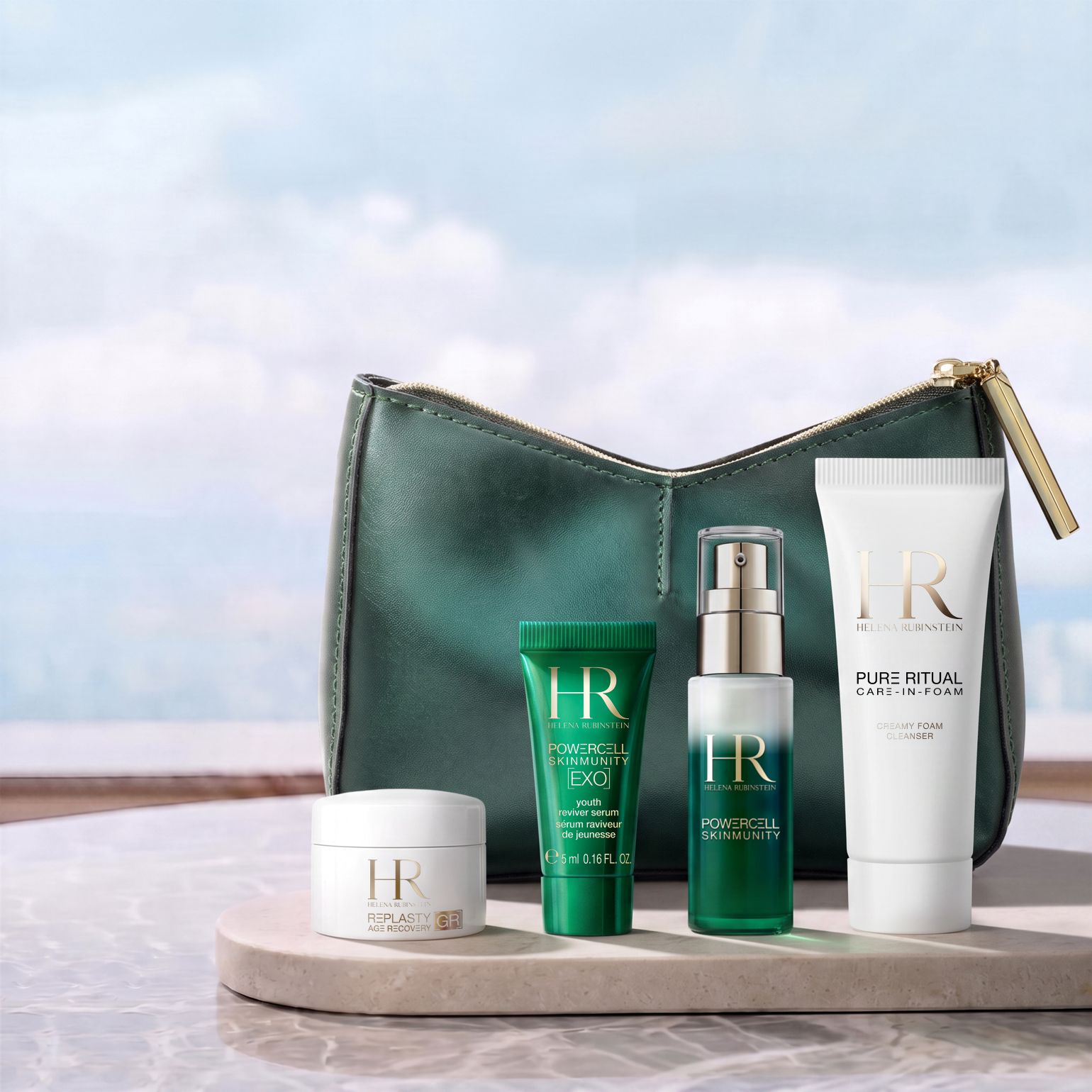 Una trousse di bellezza verde di Helena Rubinstein posizionata davanti a uno sfondo luminoso, circondata da quattro prodotti in miniatura: una crema Re-Plasty, un mini siero Powercell [EXO], un siero Powercell Skinmunity e un detergente Pure Ritual.​
