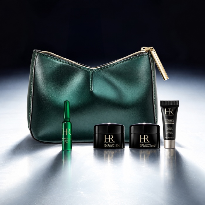 Una trousse di bellezza verde di Helena Rubinstein posizionata davanti a uno sfondo luminoso, circondata da quattro prodotti in miniatura.​